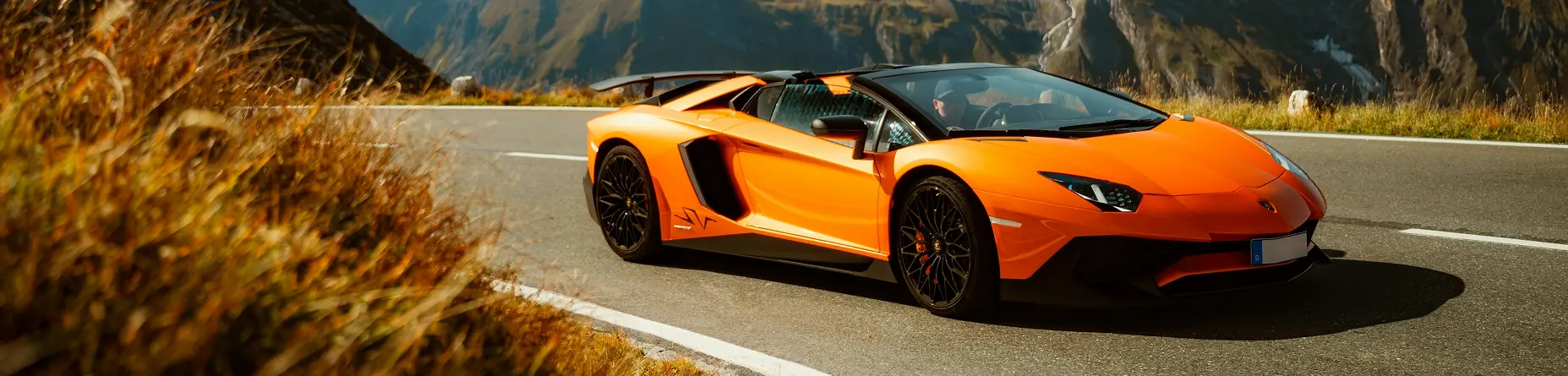 Lamborghini deportivo naranja de importación circulando por carretera de montaña